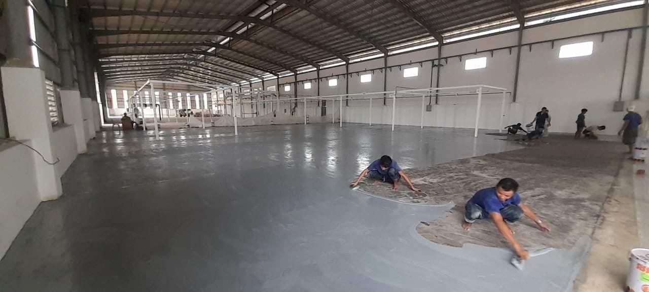 Piso industrial siendo preparado y pintado.